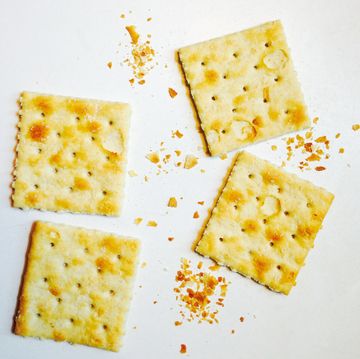 four saltine and crumbs on white