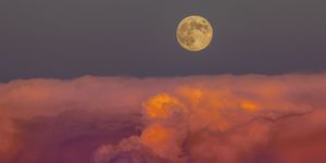 harvest moon rising above storm clouds, western colorado